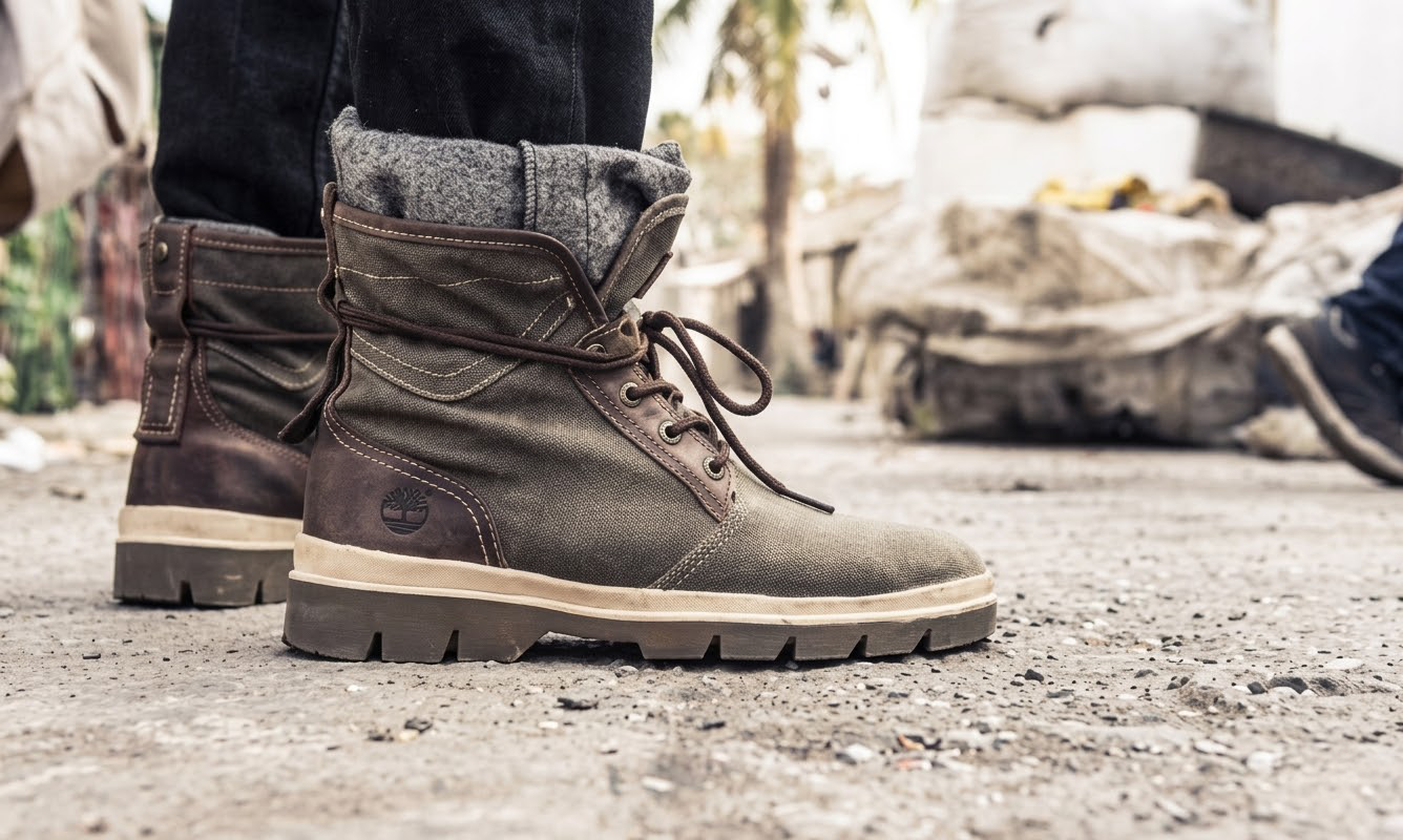 Nahaufnahme brauner Schnürstiefel auf staubiger Straße